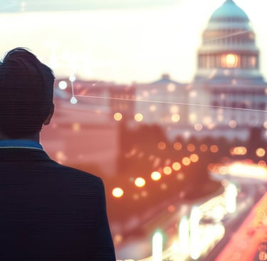 a man in a suit in a cityscape facing the United States Capital Building in Washington D.C. 