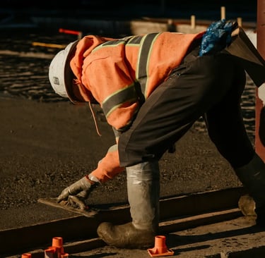 a construction worker is working on a concrete sidewalk