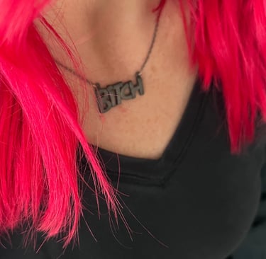 woman-with-red-hair-and-necklace-that-says-bitch