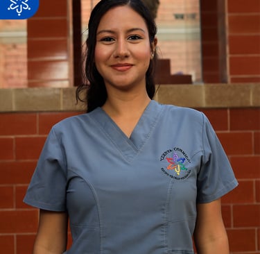 a woman in scrubs and scrubs standing in front of a brick wall