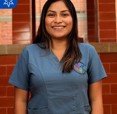a woman in scrubs and scrubs standing in front of a brick wall
