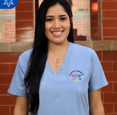 a woman in scrubs and scrubs standing in front of a brick wall