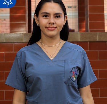 a woman in scrubs and scrubs standing in front of a brick wall