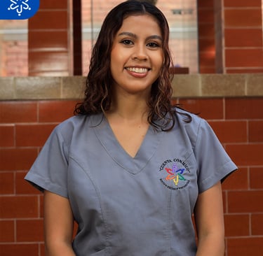 a woman in scrubs and scrubs standing in front of a brick wall