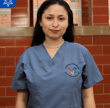 a woman in scrubs and scrubs standing in front of a brick wall