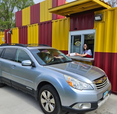 Bright red and yellow HeckYA shipping container drive-through restaurant on McCartney Rd Youngstown