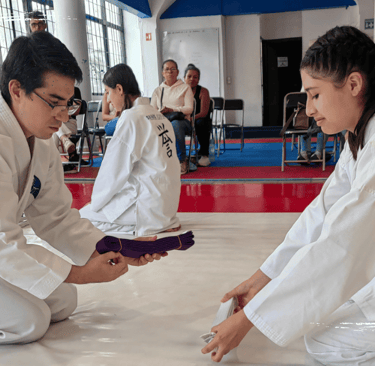 Alumna de karate recibiendo su nueva cinta despues de un examen de karate en narvarte