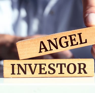 person holding wooden blocks that read "angel" "investor"