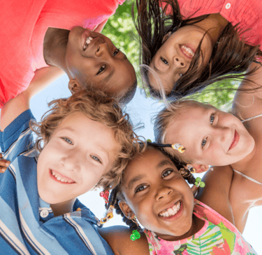 Group of smiling kids looking down at the camera