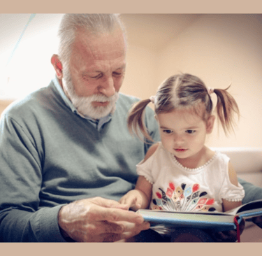 Elderly gentleman reading to a preschooler