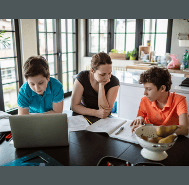Mom helps her teen boys with their homeschool assignments