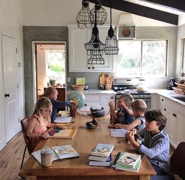 Children working on homeschool lessons at the kitchen table
