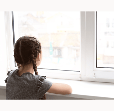 Young girl looking at out the window