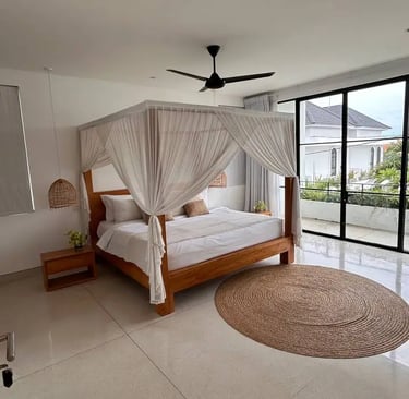 Cozy bed facing tropical greenery in a modern Balinese villa