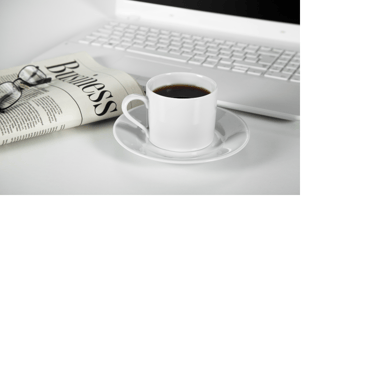 Pic of a folded newspaper with glasses on top, a mug of coffee, and a laptop