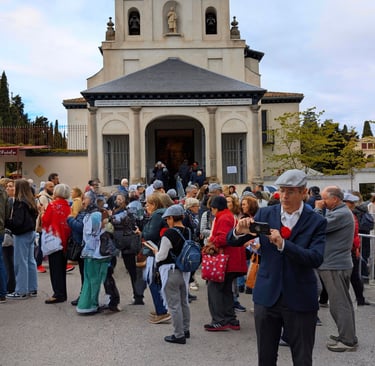 A bustling scene in front of the ermita de San Isidro, with a large crowd of people waiting outside.