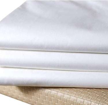 a stack of white sheets and pillows on a bed