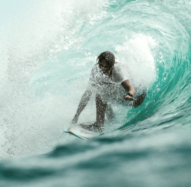 un hombre en una tabla de surf sobre una ola