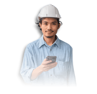 A person in a blue denim shirt and white hard hat holds a smartphone in front of a black background.
