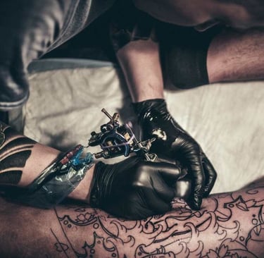 a man is getting a tattoo on his arm