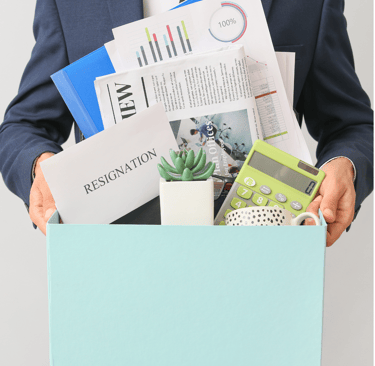 homem demitido segurando uma caixa com seus pertences