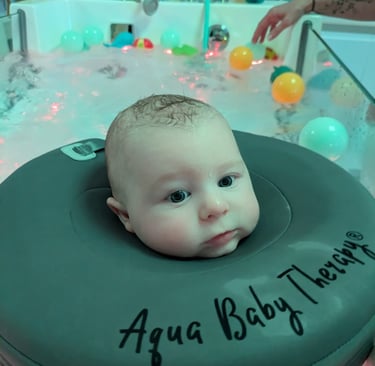 bébé dans le bain avec une bouée de cou