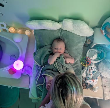 bébé après un bain se faisant masser par la praticienne