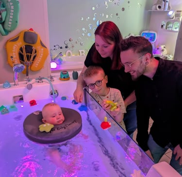 famille heureuse regardant leur bébé dans le bain d'hydrothérapie