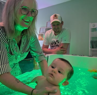 bébé détendu dans le bain avec le papa qui le regarde