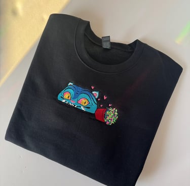 a black sweatshirt with a blue cat embroidered on it