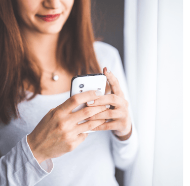 Mulher com celular na mão chamando conserto da geladeira