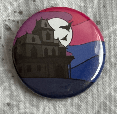 An image of a pin badge with a haunted house illustration in the colours of the bisexual flag.