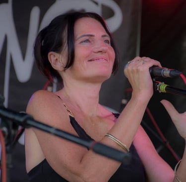 Claire Long singing at a festival summer 2025