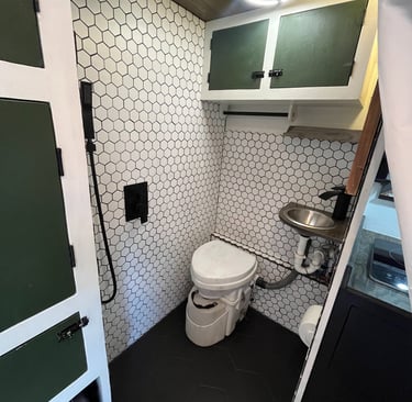 tiled shower inside epic overlanding rig, composting toilet, small sink and rainfall showerhead