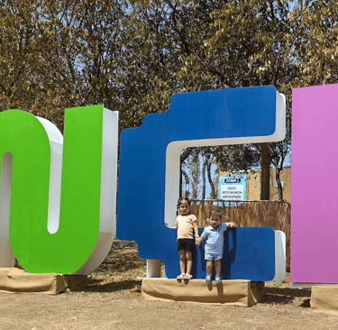 a young girl and boy standing in front of a large sign that says, 'brunch"