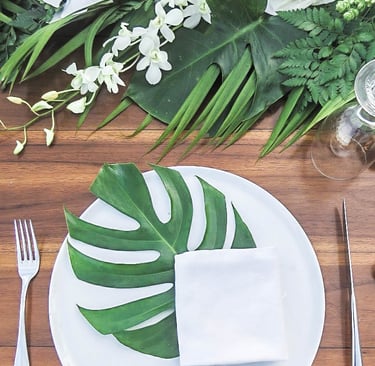 simple and elegant wedding reception plate decor with tropical leaf