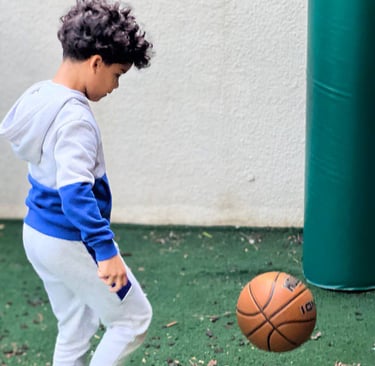 a young boy playing with a basketball ball FANTASTIC LAND LEARNING CENTER