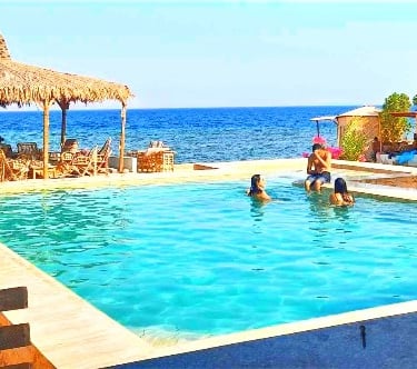 People in the pool with sea view at Bedouin star Ras shitan Nuweiba Egypt