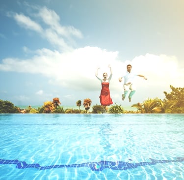 Couple jumping into a swimming pool