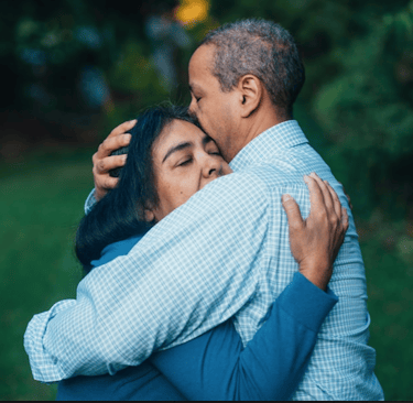 Couple cuddling looking sad