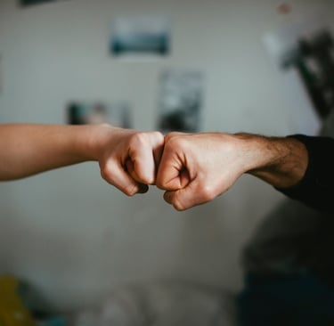 Empty nester parent giving fist bump to their adult child