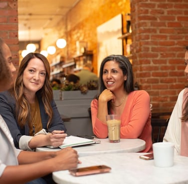 Four women sat together in a cafe talking