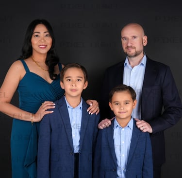 Smiling parents and kids sharing a loving moment in a beautifully lit family portrait.