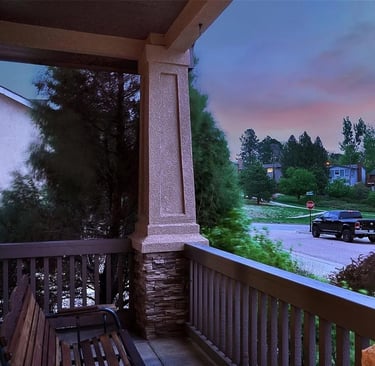 a bench on a porch with a bench and a car parked in front of it