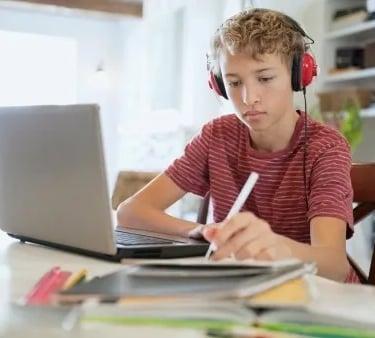 a boy with headphones and headphones on a laptop