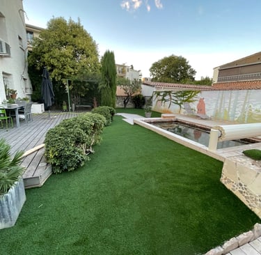 Aménagement de jardin avec gazon synthétique et terrasse bois réalisé par paysagiste à Montpellier