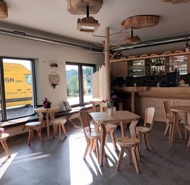 Hotelbar aus Massivholz mit ausgefallenen Sitzgruppen und Deckenlampen aus Baumscheiben