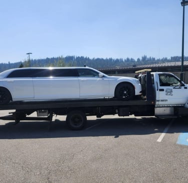 a white limo loaded on a tow truck