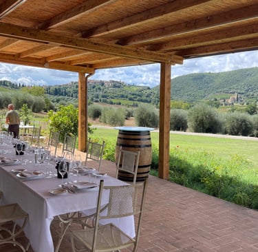 Déjeuner d'entreprise dressé sous la pergola, vue panoramique sur les collines d