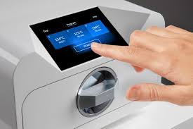 Hand operating an autoclave for sterilising piercing jewellery at Piercing by Jooles Montrose